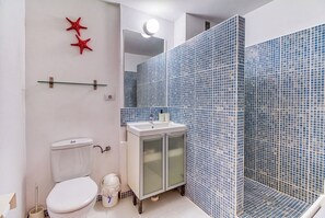 A bathroom with a toilet, sink, and shower area. - Apartamento Delphin Sol – Sea Views and Beachfront Location in Puerto Naos (Puerto de Naos)