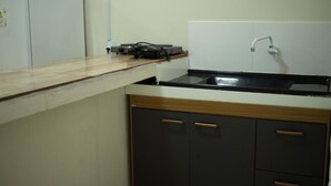 A kitchen with a countertop, a sink, and cabinets. - Hospedaria Valdice Damasceno (Piranhas)