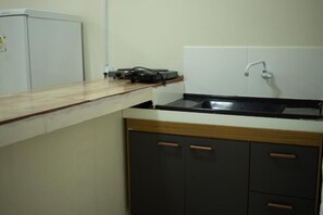 A kitchen with a countertop, a sink, and cabinets. - Hospedaria Valdice Damasceno (Piranhas)
