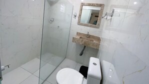A bathroom with a glass-enclosed shower, a toilet, and a sink with a marble countertop. - Hospedaria Valdice Damasceno (Piranhas)