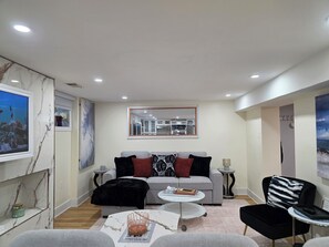 Una sala de estar moderna con sofá, mesa de centro y una mesita auxiliar.