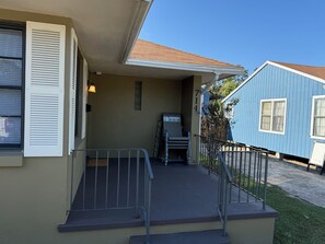 A residential property with a covered porch, a mailbox, and a small mailbox stand. - Cozy 2-bedroom house in peaceful Corpus Christi close to hospital beach downtown (Corpus Christi)