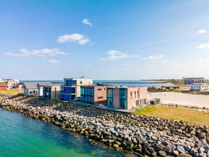 Ein Küsteneigentum mit moderner Architektur, einer felsigen Küstenlinie und Blick aufs Meer.