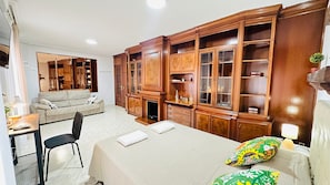 Una habitación de hotel con una cama, un sofá, un escritorio y un armario de madera grande.