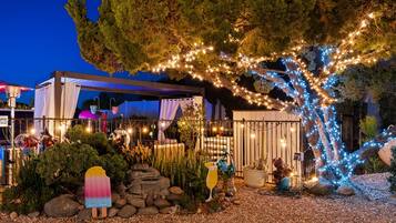 A garden area with a pergola, potted plants, and decorative lighting.