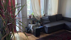 A living room with a sectional sofa, a coffee table, and a potted plant. - Luxury Apartment - The subway is right outside the apartment (Stockholms län)