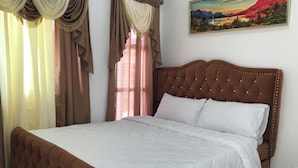 A bedroom with a large bed, a tufted headboard, and curtains. - Superhost Home - 2 min Airport -Pool WiFi - Samal (Davao)