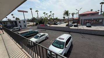 A motel with a parking lot, several parked cars, and a building with a red roof.