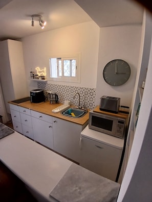 A compact kitchen with a microwave, toaster, sink, and a clock on the wall. - Cosy private two bed apartment with exclusive use of swimming pool. (Torrox)