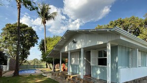 A house with a covered porch, a swimming pool, and a paved walkway. - Country house with sand court and heated pool. (Americana)
