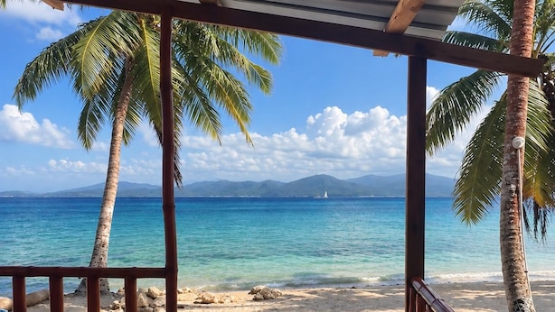 A covered beach area with a view of the ocean and palm trees. - cabaña madera sanblas luxury  (Nusatupo)