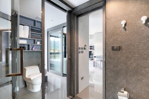 Ein modernes Badezimmer mit einer Duschkabine aus Glas, einer Toilette und einem Waschtisch mit Spiegel.