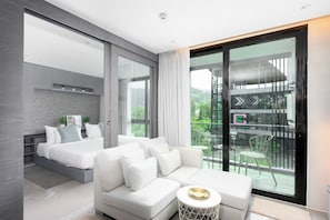 A modern bedroom with a bed, a sofa, and a balcony with a view of London. - Kamala - Peaceful Jungle View (Kathu District)