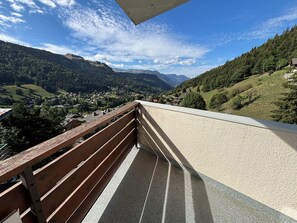 Ein Balkon mit Blick auf ein Tal und Berge.