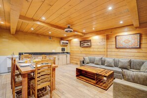 A wooden interior with a dining area, sofa, and a ceiling fan. - DanCenter Riverside Lexus Regency (Pahalgam)