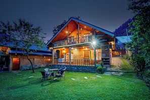 A two-story wooden lodge with a balcony, outdoor seating, and a stone pathway leading to the entrance. - DanCenter Riverside Lexus Regency (Pahalgam)