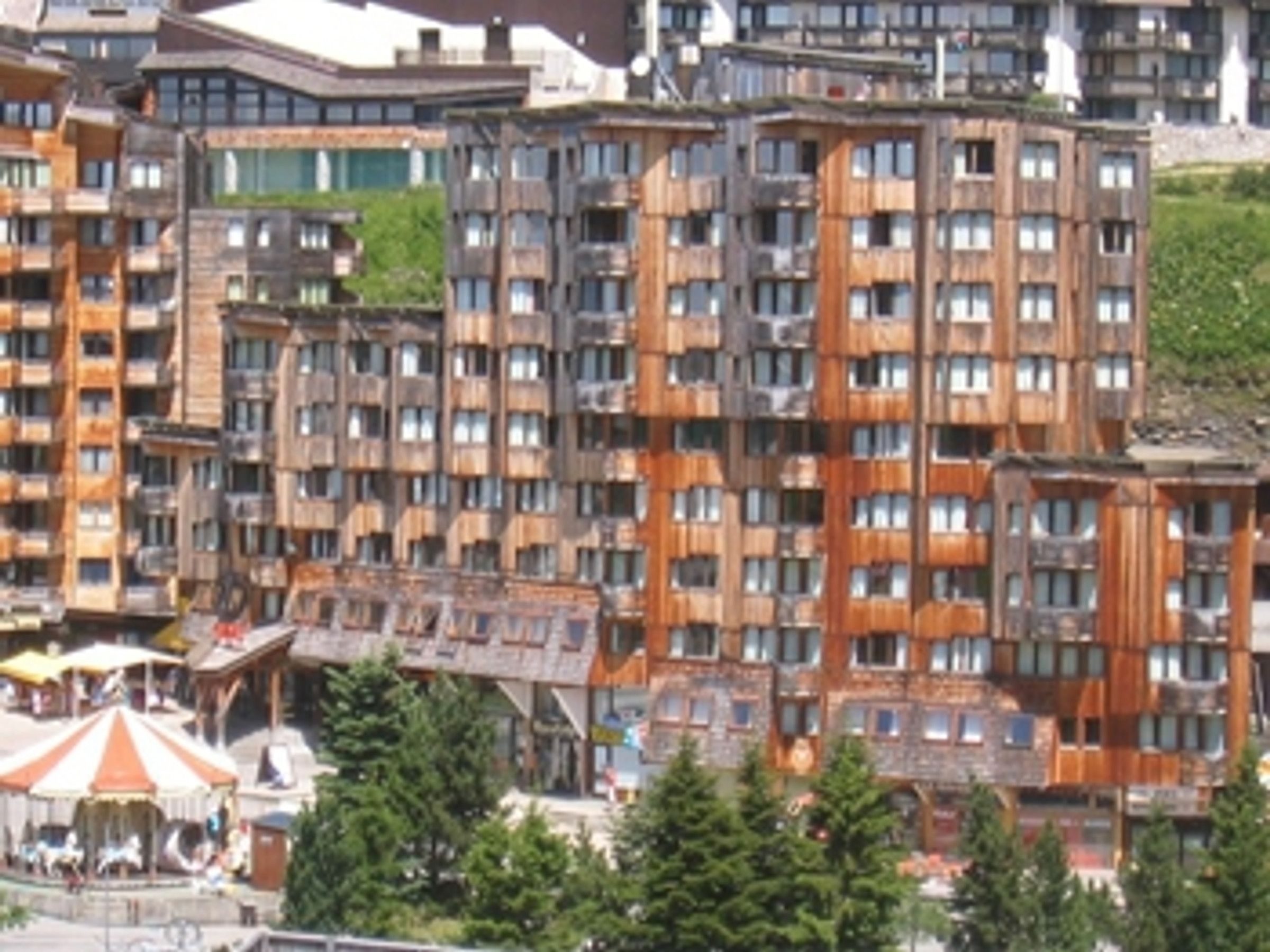 A multi-story hotel with a modern architectural design, featuring balconies and large windows.