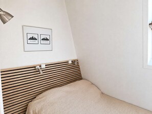 A corner bedroom with a slatted headboard, a framed picture on the wall, and a window on the right. - Cozy apartment, pets welcome - 6 guests (Saint-Michel-de-Chaillol)