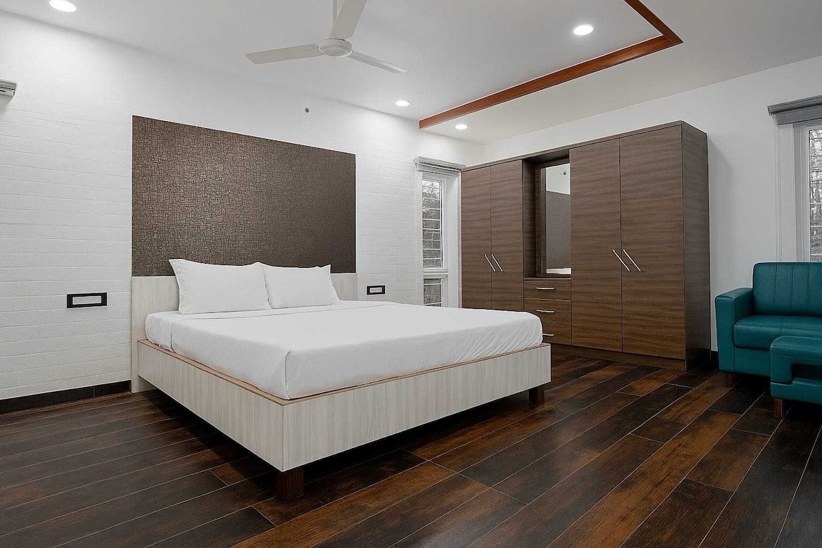 Un dormitorio moderno con cama, armario y una silla color turquesa.