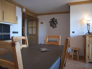 A dining area with a table, chairs, a clock, and a wall decoration. - 3-room apartment with indoor pool, parking and Wifi at Arc 1800 (Les Arcs 1800)