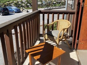 A wooden chair with a cushion on a balcony with a railing. - Mezzanine studio near slopes - 4 guests (Arêches-Beaufort)