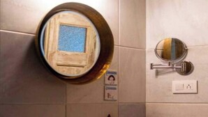 Un baño con lavamanos, espejo y un pequeño portavasos.