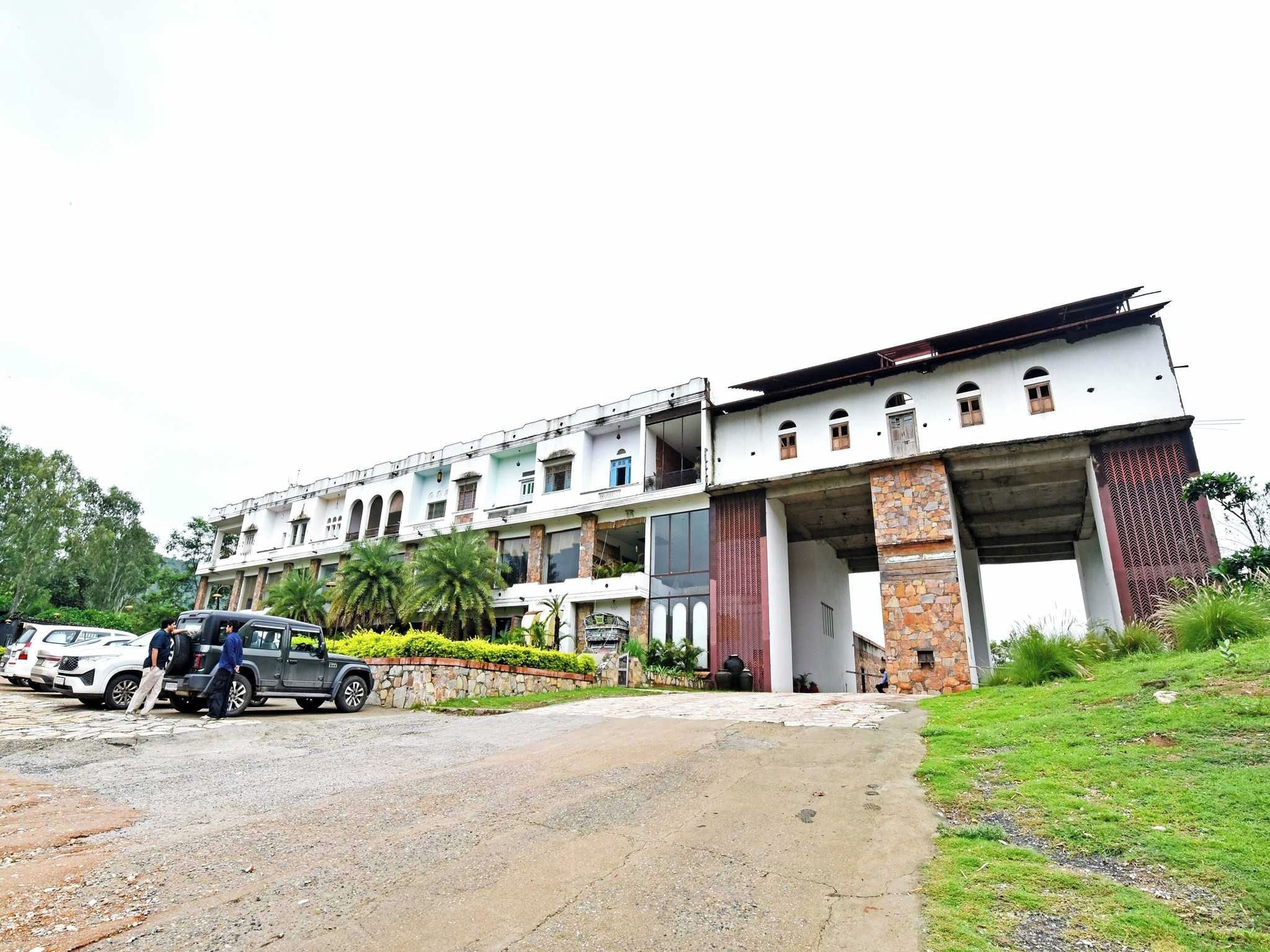 Un edificio de varios pisos con una entrada amplia y un corredor cubierto.