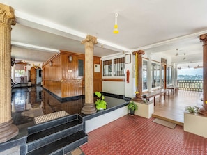 A spacious lobby with a marble floor, wooden paneling, and a view of the city.