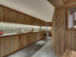Eine moderne Küche mit Holdekor, einer langen Arbeitsplatte und einem eingebauten Ofen.