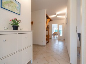 A hallway with a white cabinet, a potted plant, and a map on the wall. - Holiday Home With 3 Bedrooms (St. Peter-Ording)