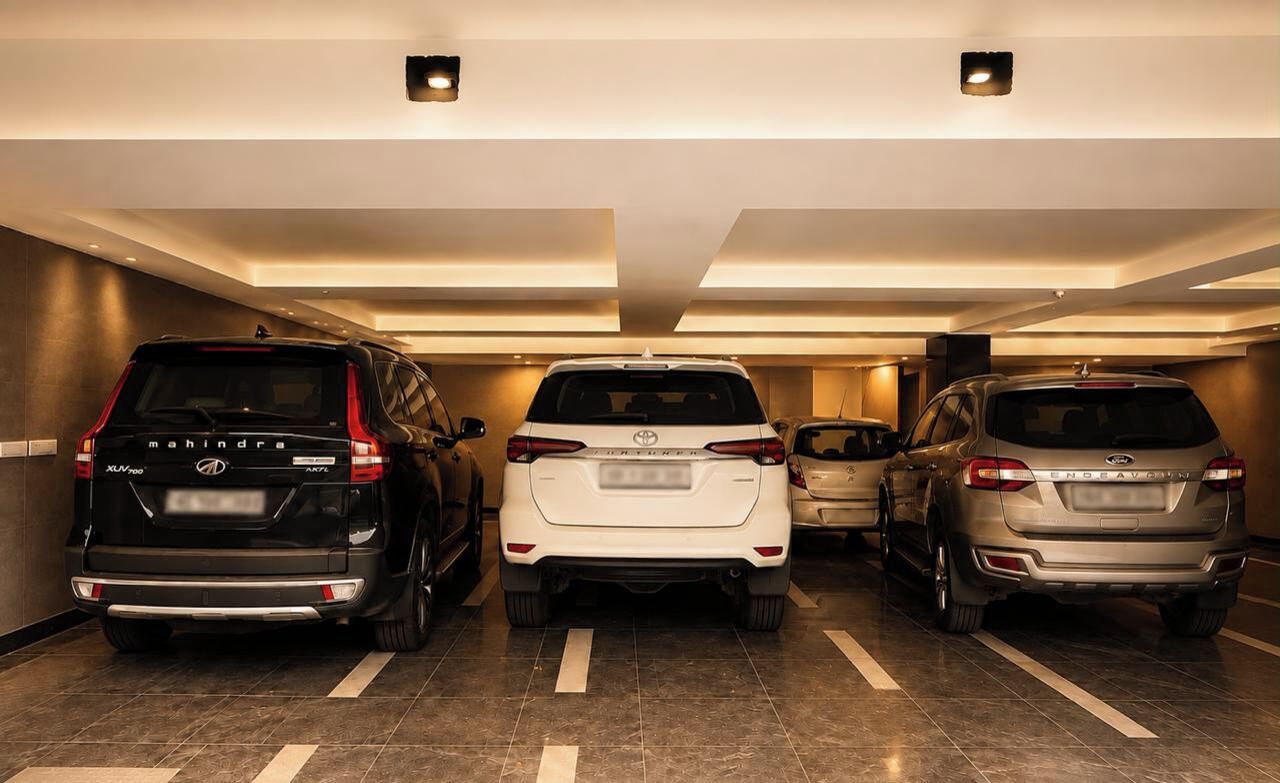 A parking garage with three cars parked in a row.