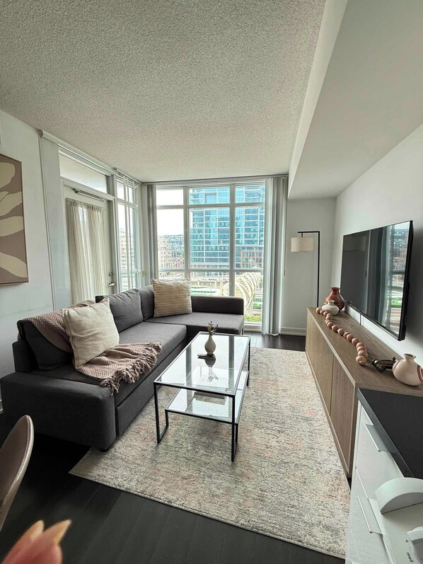 A modern living room with a sofa, coffee table, and a TV.