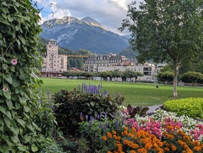A park with a variety of flowers and a building with a tower in the background. - The Centralstrasse Apartment | Heart of Interlaken (Interlaken)