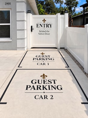 A gated entrance with a sign indicating 'ENTRY Behind the Velvet Door' and two guest parking areas marked 'GUEST PARKING CAR 1' and 'GUEST PARKING CAR 2'.