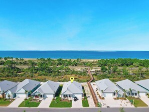 A residential area with houses, a beach, and a clear sky. - Luxurious-GolfCart-OceanView-BeachGear-Games (Port St. Joe)
