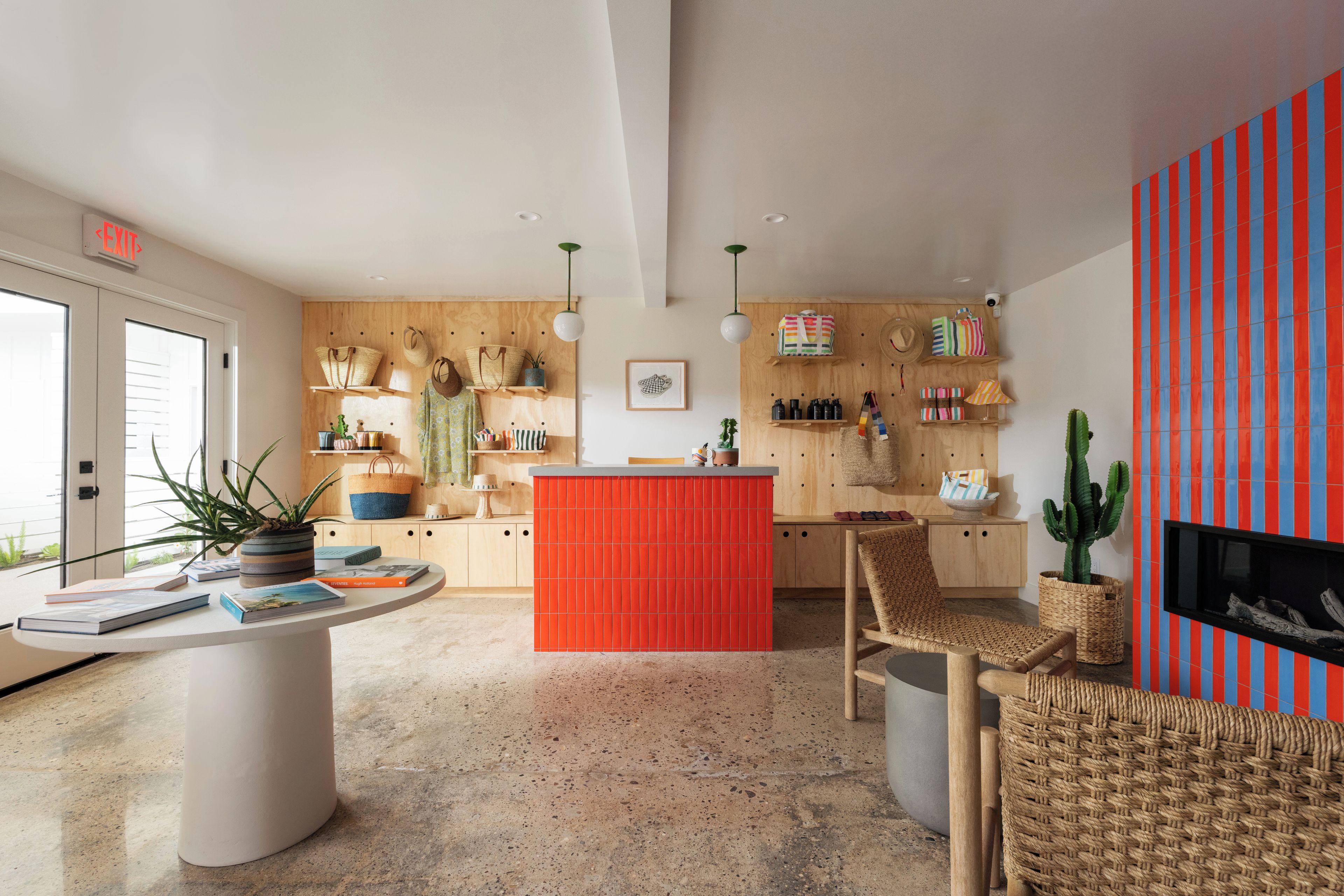 Una cocina moderna con una isla central, armarios de madera y una pared de acento roja.