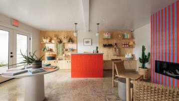 Una cocina moderna con una isla central, armarios de madera y una pared de acento roja.