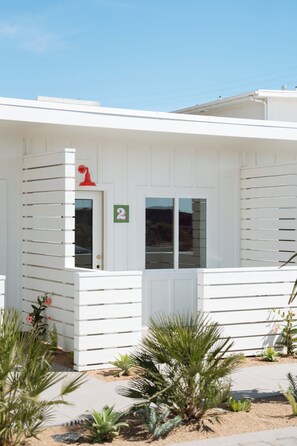 A white building with a number 2 sign, a door, and windows.