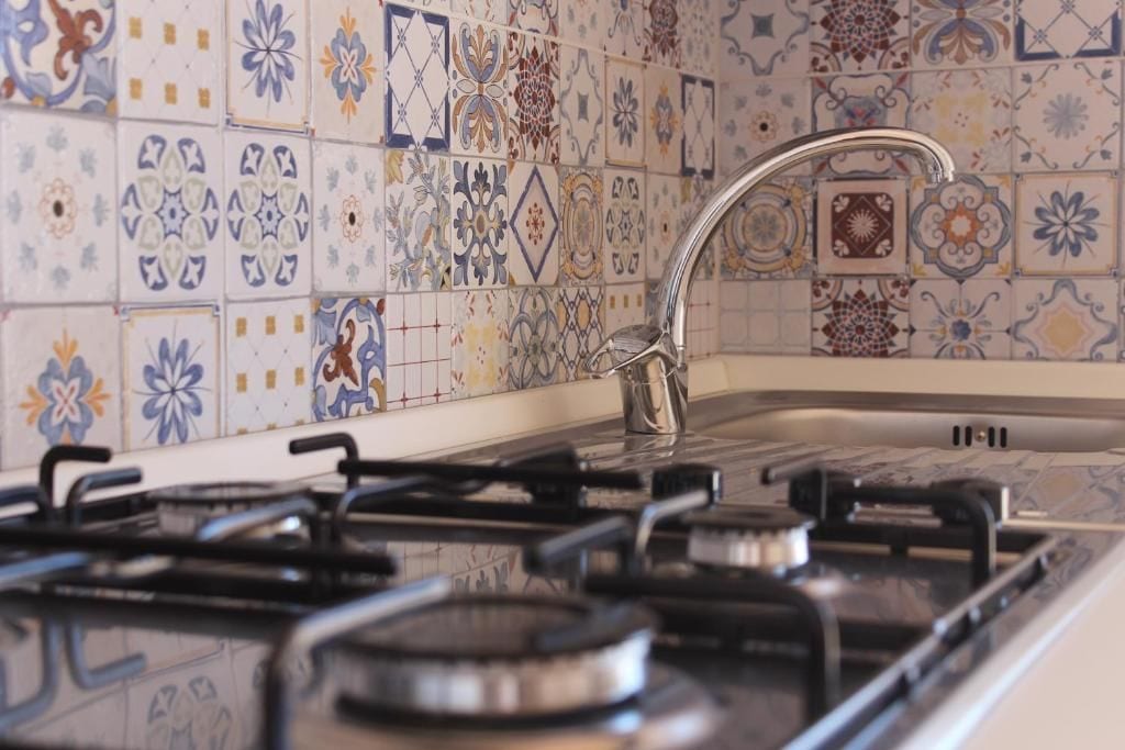 A kitchen with a gas stove and a modern faucet.