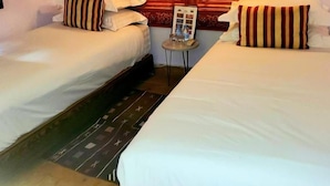 A hotel room with two single beds, a small table with a lamp, and a wooden headboard with a mirror. - Riad Rêve D'antan Dream (Marrakech)