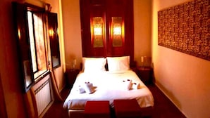 A hotel room with a large bed, two bedside tables, a wardrobe, and a wall-mounted artwork. - Riad Rêve D'antan Dream (Marrakech)