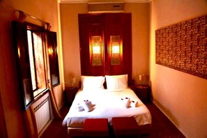 A hotel room with a large bed, two bedside tables, a wardrobe, and a wall-mounted artwork. - Riad Rêve D'antan Dream (Marrakech)