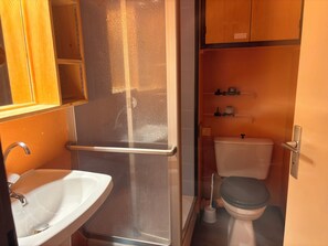 A compact bathroom with a sink, toilet, and a small shelf with toiletries. - Peisey-Loue: Apartment at the base of the slopes, sleeps 6 (Peisey-Nancroix)