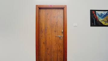 Eine Holztür mit einem Metallgriff und einem kleinen Schild darüber.