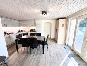 A modern kitchen with a dining area, wooden cabinets, and a large window. - Chalet Apartment 5 Minutes Walk to Medran Lifts (Val de Bagnes)