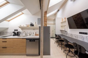 Een moderne keuken met een dakraam, een vaatwasser en een lange aanrecht met stoelen.