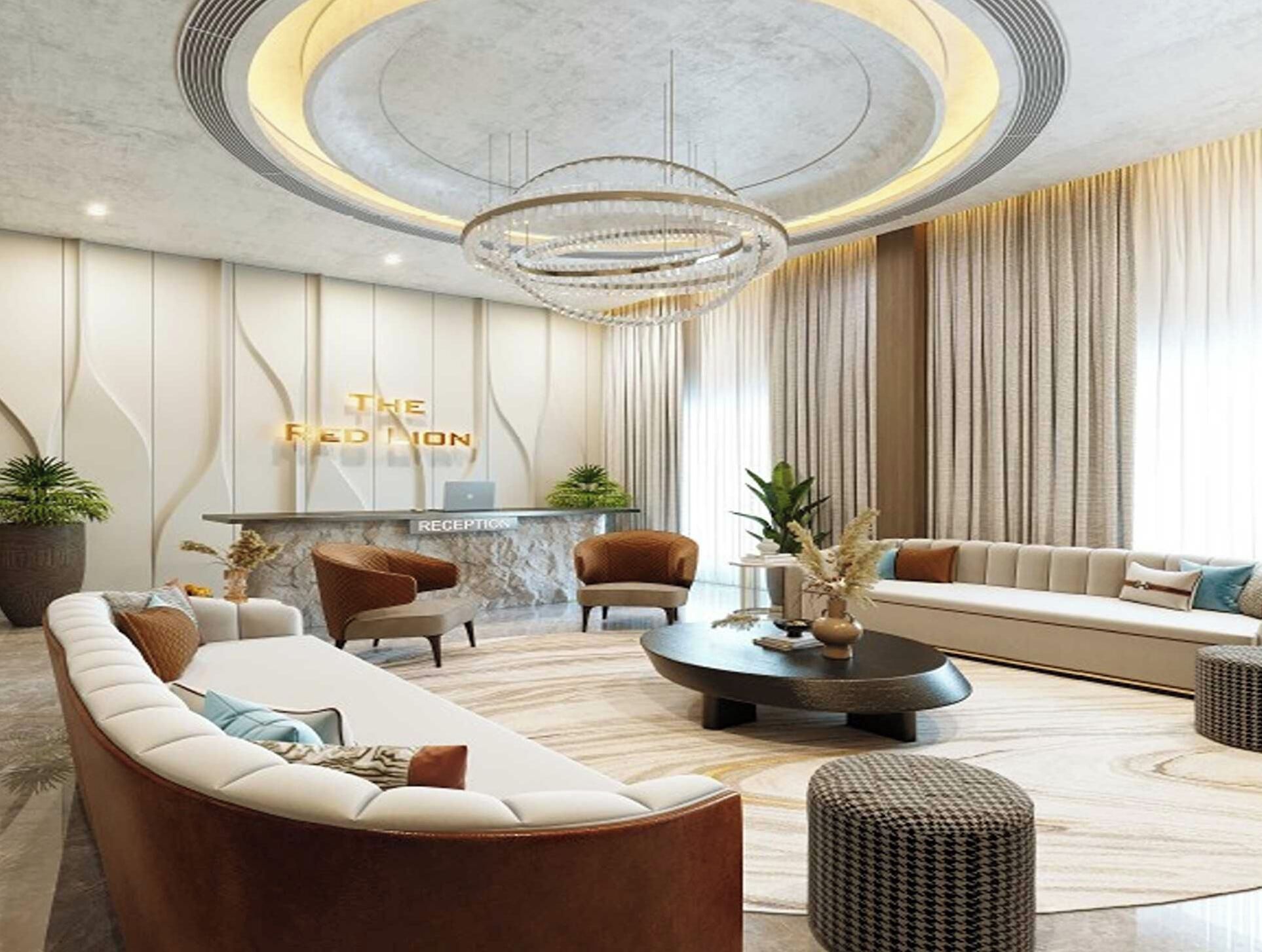 A modern reception area with a sofa, chairs, a reception desk, and a chandelier.
