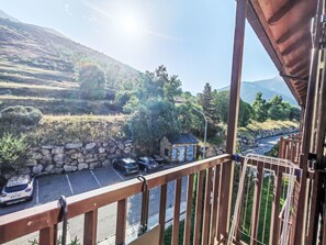 Ein Balkon mit Blick auf einen Parkplatz und eine Steinmauer.