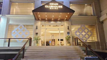 Das äußere Erscheinungsbild des Chekin Clubhouse Hotels mit einem markanten Eingang, einer Treppe, die zum Eingang führt, und dekorativen geometrischen Mustern an der Fassade.