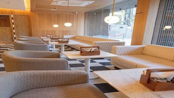 A modern interior with seating arrangements, tables, and pendant lighting.